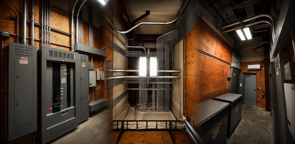 Commercial electrical room with conduit runs, switchgear panels, and industrial wiring installation